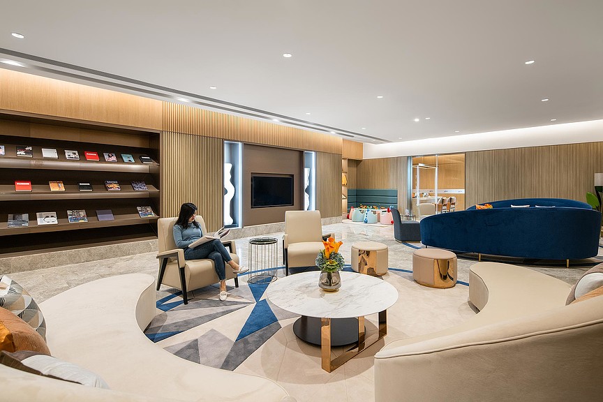 A person sitting in a chair in a large room with a large tv.